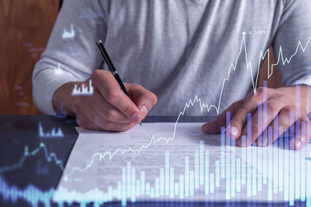 A client in casual wear is signing the contract to invest money in stock market. Internet trading...