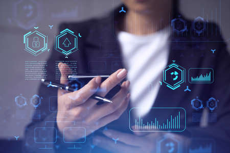 Businesswoman in formal wear holding in the hands a smart phone and testing an innovative...
