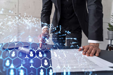 HR specialist researching and analyzing the data of salary on employment market to forecast ongoing expenses of the company using calculator. Hiring new talented officers. Social media hologram iconsの写真素材