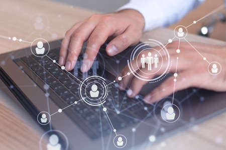 Hands of hr specialist is typing the keyboard in the internet to find the best candidates to create international network in recruitment process. Formal wear. Social media hologram icons.の写真素材
