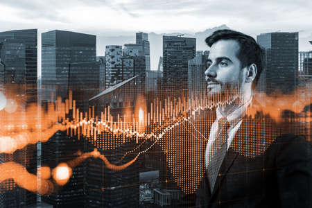 A young Caucasian handsome trader and stock market analyst in suit dreaming about market behavior and forecast in crisis. Trading at corporate finance fund. Forex chart. Singapore. Double exposureの写真素材