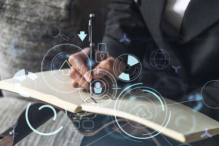 Businesswoman is writing down some ideas to create innovative software to change the world and provide a completely new service. Close up shot. Hologram tech graphs. Concept of Dev team. Formal wear.の写真素材