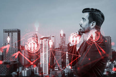 Handsome Caucasian HR director at international company is thinking about efficient strategy to recruit highly qualified specialists. Social media and marketing hologram icons over Bangkok background.の写真素材
