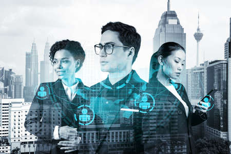 Group of SMM specialists working on social media marketing strategy to achieve business goals. Hologram icons over Kuala Lumpur background.の写真素材
