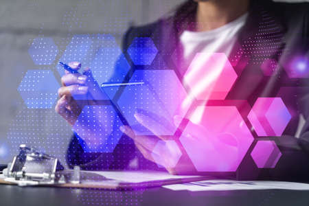 Businesswoman taking notes using smart-phone. Abstract technology hologram double exposure.の写真素材