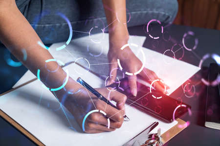 Businesswoman taking notes using smart-phone. Abstract technology hologram double exposure.