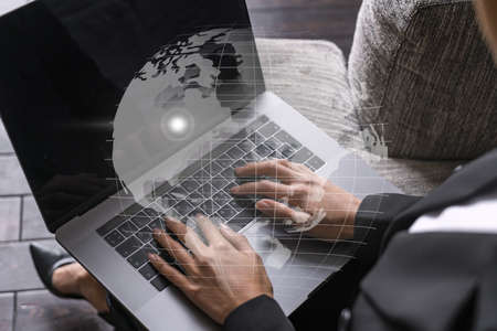 Businesswoman typing on laptop in office. Planet earth world map hologram. International business concept. Double exposure.の写真素材