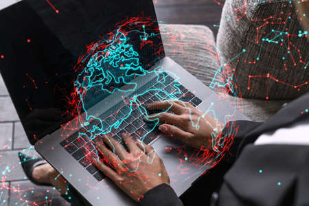 Businesswoman typing on laptop in office. Planet earth world map hologram. International business...