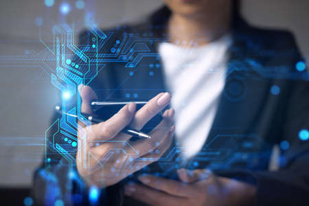 Businesswoman typing phone in office. High-tech hologram. International business concept. Double exposure.の写真素材