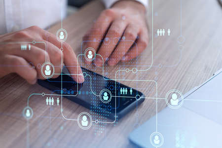 Hands of hr specialist browsing social networks in the Internet in smart phone to find the best...
