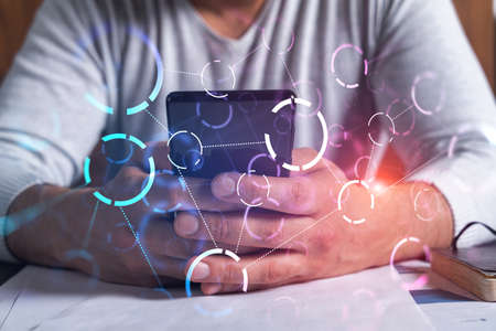 Man using phone. Hands typing smartphone. Double exposure with abstract tech network hologram. Close...