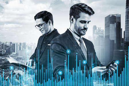 Two young handsome businessman in suits working on forecasting trading corporate strategy at fund. Forex chart. Singapore on background. Double exposure.の写真素材