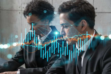 Two businesspeople working on market behavior. Trading concept. Forex graph. hologram.の写真素材
