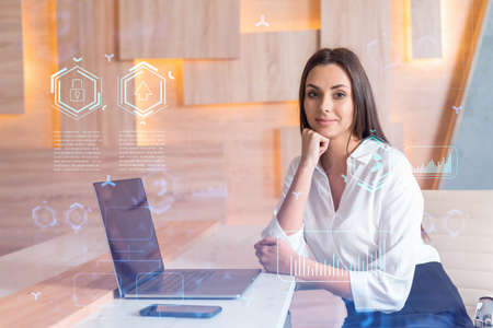 Attractive businesswoman in white shirt at workplace working with laptop to optimize development by...
