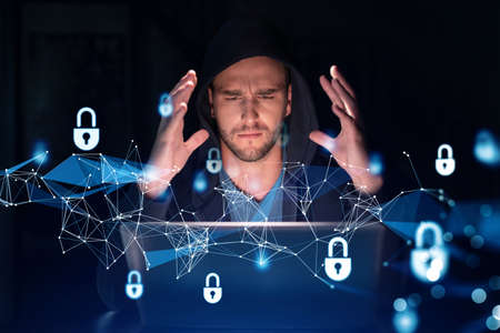 Handsome businessman in hoodie at workplace working with laptop to defend customer cyber security....