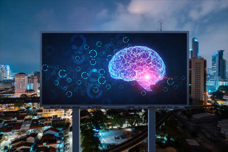 Brain hologram on billboard with Kuala Lumpur cityscape background at night time. Street advertising...