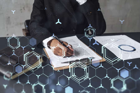 African American businesswoman is signing a contract to create a new software to present it in start up conference and gain investments to create a product. Technological graph over the desk.の写真素材