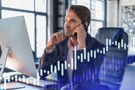 Businessman in suit has conference call to optimize trading strategy at corporate finance fund. Forex chart hologram over office background with panoramic windowsの写真素材