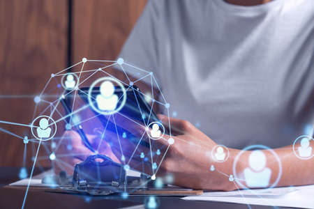 Employee signing the contract to boost her career and gain new opportunities in personal growth. Women in business concept. Checking the detail of the deal at smartphone. Social media hologram iconsの写真素材