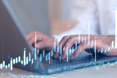 Hands typing the keyboard to research stock market to proceed right investment solutions. Internet...