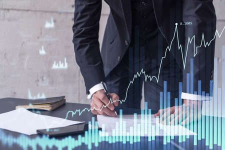 A client in formal wear is signing the contract to invest money in stock market. Internet trading...