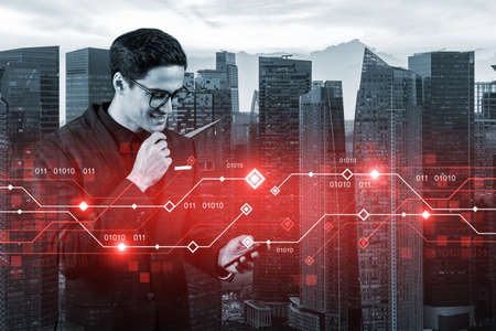 A handsome eastern businessman trying to achieve tremendous growth in commerce using new technological approaches by researching the internet in smartphone. Tech hologram icons over Singaporeの写真素材