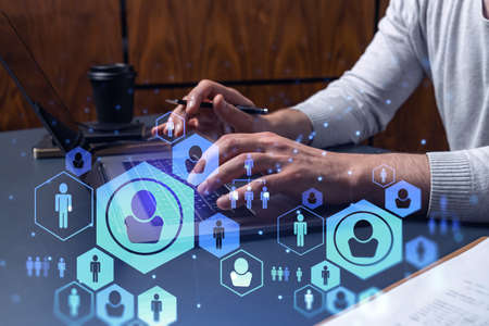 Hands of hr specialist is typing the keyboard in the internet to find the best candidates to create...