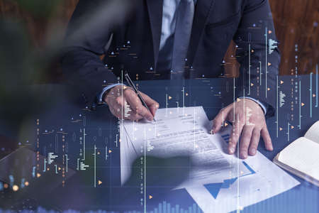 A client in formal wear is signing the contract to invest money in stock market. Internet trading...