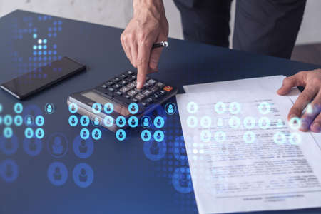 HR specialist researching and analyzing the data of salary on employment market to forecast ongoing expenses of the company using calculator. Hiring new talented officers. Social media hologram iconsの写真素材