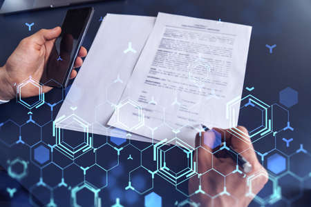 A client in dark blue suit is signing a contract to create a new software to present it in start up conference and gain investments to create a product. Technological graph over the desk.の写真素材