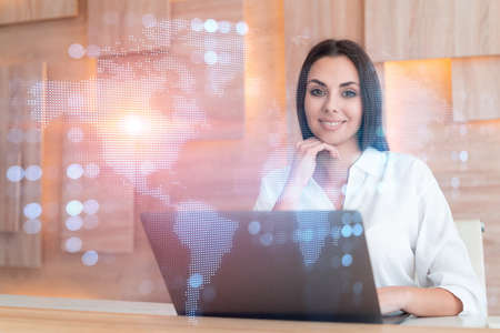 Attractive businesswoman in white shirt at workplace working with laptop to hire new employees for...