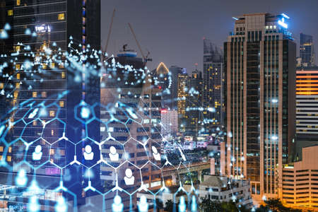 Glowing social media icons on night panoramic city view of Bangkok, Southeast Asia. The concept of...