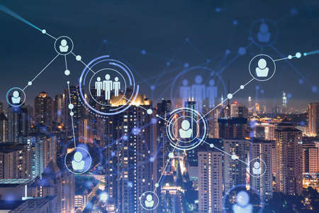 Glowing social media icons on night panoramic city view of Kuala Lumpur, Malaysia, Asia. The concept of networking and establishing new connections between people in businesses in KL. Double exposure.の写真素材