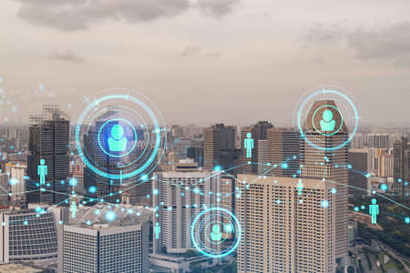 Hologram of social media icons over sunset panoramic cityscape of Singapore, Southeast Asia. The concept of people connections and career opportunities in international consulting. Multi exposure.の写真素材