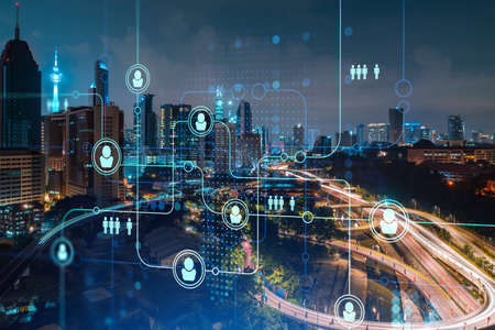 Glowing social media icons on night panoramic city view of Kuala Lumpur, Malaysia, Asia. The concept...
