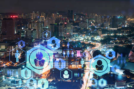 Glowing social media icons on night panoramic city view of Kuala Lumpur, Malaysia, Asia. The concept...