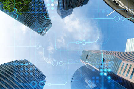 Technology hologram over low angle shot of Singapore skyscrapers. The largest tech hub in Southeast...