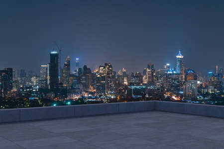 Panoramic Bangkok skyline view, concrete observatory deck on rooftop, night time. Asian corporate and residential lifestyle. Financial city downtown, real estate. Product display mockup empty roofの写真素材