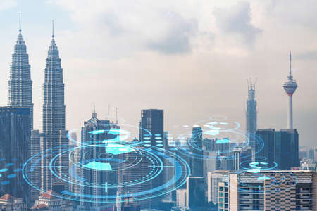 Technology hologram over panorama city view of Kuala Lumpur. KL is the largest tech hub in Malaysia, Asia. The concept of developing coding and high-tech science. Double exposure.の写真素材