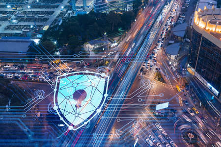Glowing padlock hologram over night busy road traffic in Bangkok city, Southeast Asia. The concept of cyber security to protect companies. Double exposure.の写真素材
