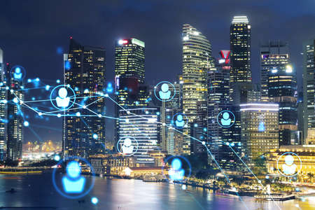 Glowing Social media icons on night panoramic city view of Singapore, Asia. The concept of networking and establishing new connections between people in businesses. Double exposure.の写真素材