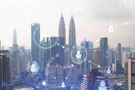 Social media icons hologram over panorama city view of Kuala Lumpur, Malaysia, Asia. The concept of people networking, connections and career opportunities. Double exposure.の写真素材