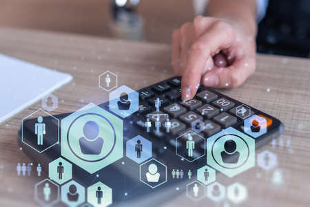 HR specialist researching and analyzing the data of salary on employment market to forecast ongoing expenses of the company. Hiring new talented officers. Social media hologram icons. Woman hand.の写真素材