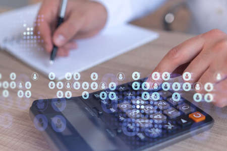 HR specialist researching and analyzing the data of salary on employment market to forecast ongoing expenses of the company using calculator. Hiring new talented officers. Social media hologram iconsの写真素材