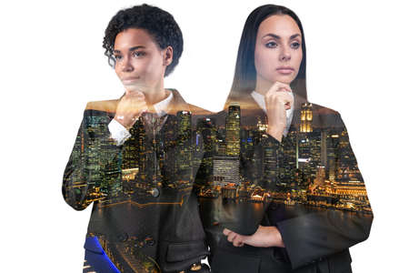 Two attractive businesswomen in suits, hand on chin. Asia corporate lifestyle, multinational diverse...