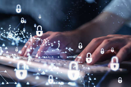 A programmer is typing a code on a keyboard to protect a cyber security from hacker attacks and save...