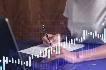 A client in casual wear is signing the contract to invest money in stock market. Internet trading...