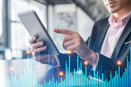 Businessman in suit using tablet device to optimize trading strategy at corporate finance fund....