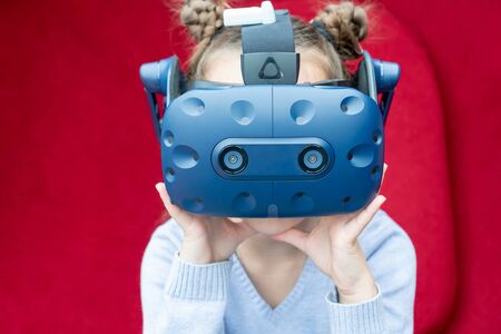Amazed young girl experiencing virtual reality with a VR headset on the head.