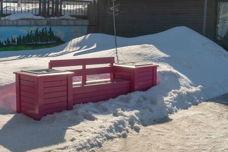 Bright pink park bench in the city in the snow in winter.の写真素材